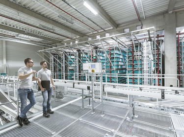 Two team members talk on top of a catwalk inside a logistics center