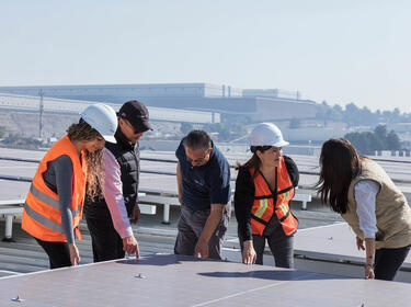 Arbeiter, die über Solarmodule schauen